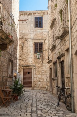 Eski duvar ve küçük kafeterya ile mermer dar sokakta. Cul-de-sac Hvar, Hırvatistan.