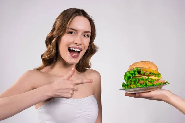Девушка счастлива, что гамбургер изолирован . — стоковое фото