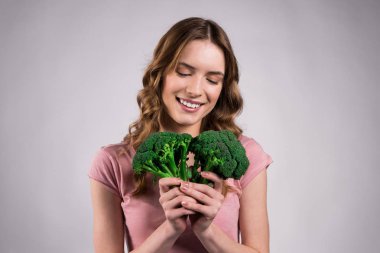 Gülümseyen kız izole brokoli ile poz.