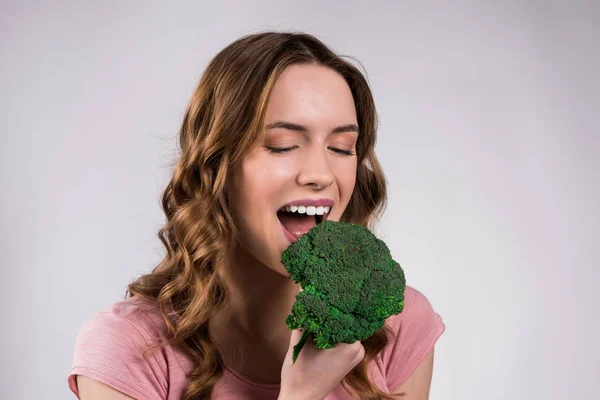 Lächeln Mädchen posiert mit Brokkoli isoliert. — Stockfoto