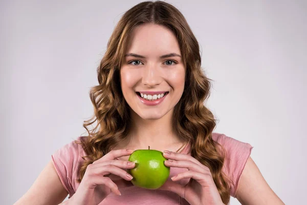 Девушка держит зеленое яблоко улыбаясь изолированы . — стоковое фото