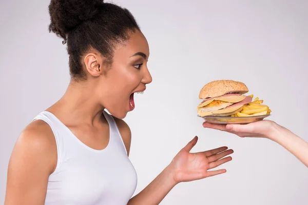 Черная девушка рада, что чизбургер изолирован . — стоковое фото