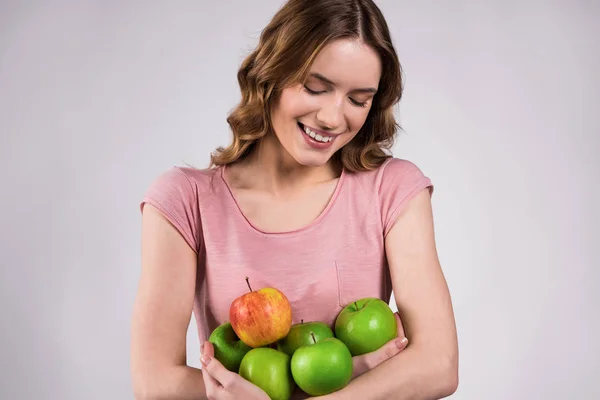 Дівчина тримає зелене яблуко, посміхаючись ізольовано . — стокове фото