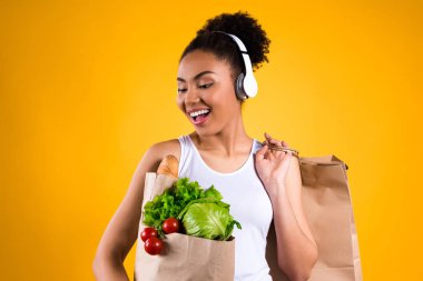 Yiyecek izole kulaklık ile siyah kız.