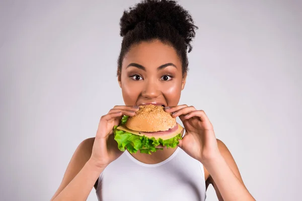 Афро-американская девушка ест гамбургер изолирован . — стоковое фото