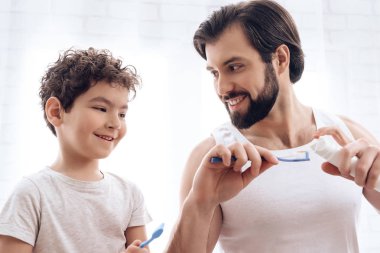 Yetişkin baba ve oğul birlikte onların fırça.