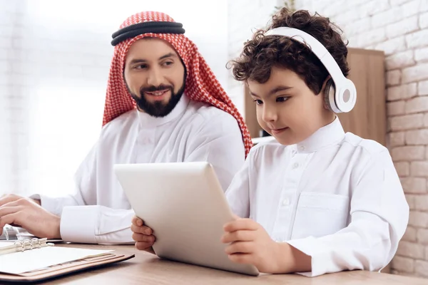 Árabe padre ayuda a poco hijo a aprender usando portátil . — Foto de Stock