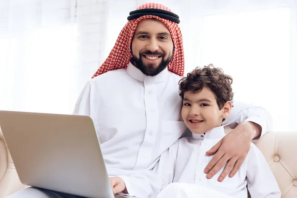 Arabian skäggiga far och son surfar webbsidor på laptop. — Stockfoto
