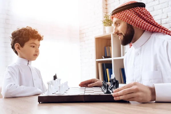 Arabian skäggiga far och Lille son spela schack. — Stockfoto