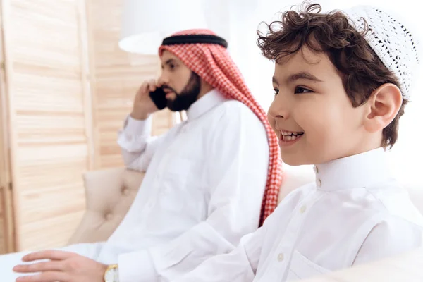 Pequeño niño pide atención de ocupado padre árabe . — Foto de Stock