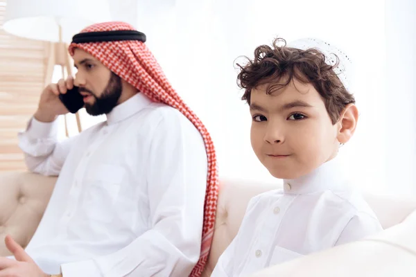 Pequeño niño pide atención de ocupado padre árabe . — Foto de Stock