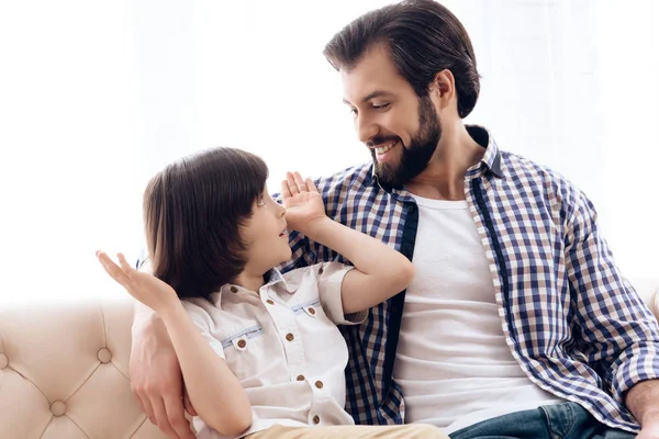 Le père barbu communique avec un fils adolescent assis sur le canapé . — Photo