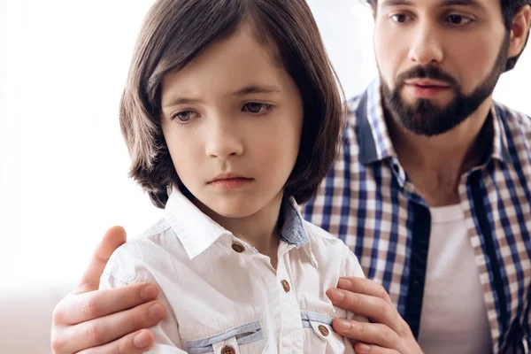 Guilty father asks for forgiveness from offended son in living room.