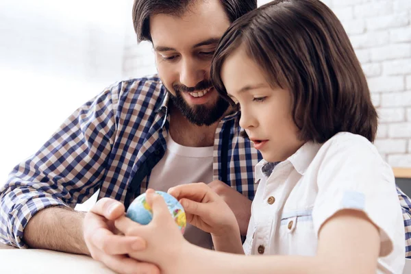 Erwachsener Vater hilft Sohn Erdkunde mit Globus zu lernen. — Stockfoto