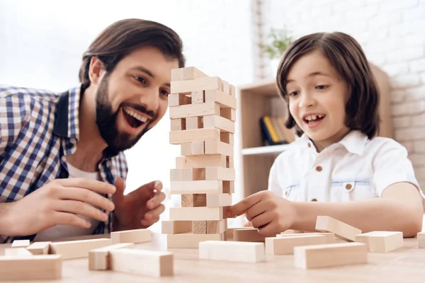 Glada far med liten son spelar Jenga hemma. — Stockfoto