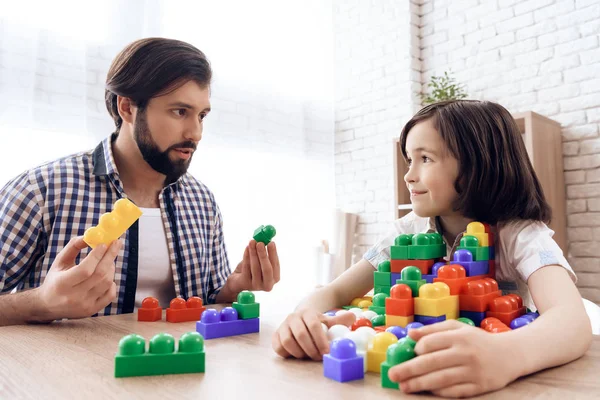 Le père barbu demande à son fils de partager des blocs de couleur jouet . — Photo