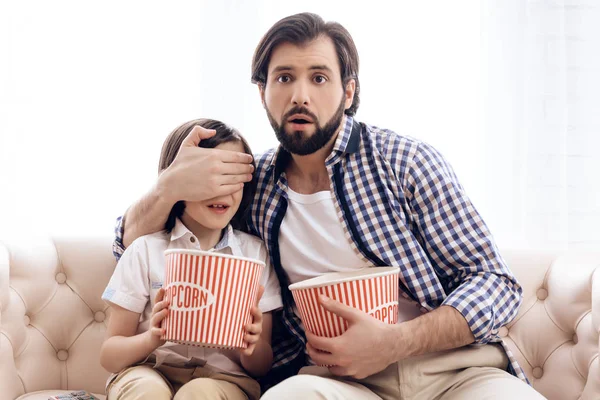 Padre cierra los ojos del hijo mientras ve la película de terror . — Foto de Stock