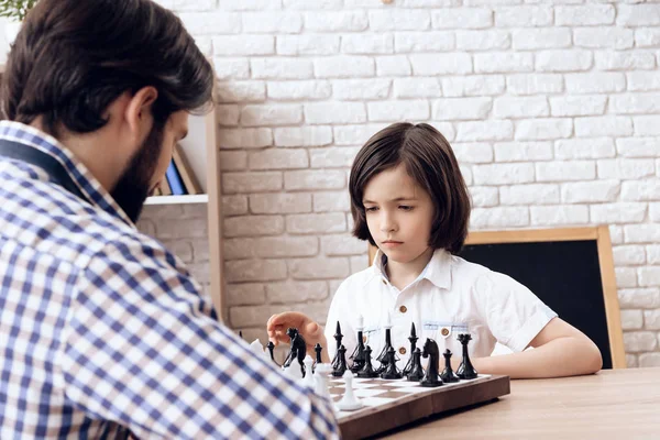 Heureux père barbu joue aux échecs avec son fils adolescent . — Photo