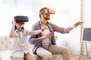 Baba ve oğul, sanal gerçeklik gözlükle interaktif bir oyun oynamak.