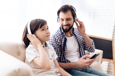 Sakallı baba ve küçük oğlu Kulaklığımda smartphone müzik dinlemek.