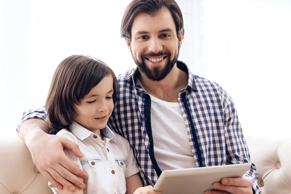 Pai feliz e filho jovem estão olhando para tablet computador . — Fotografia de Stock