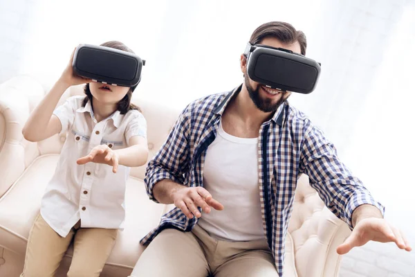 Father and son, using virtual reality glasses, play an interactive game.
