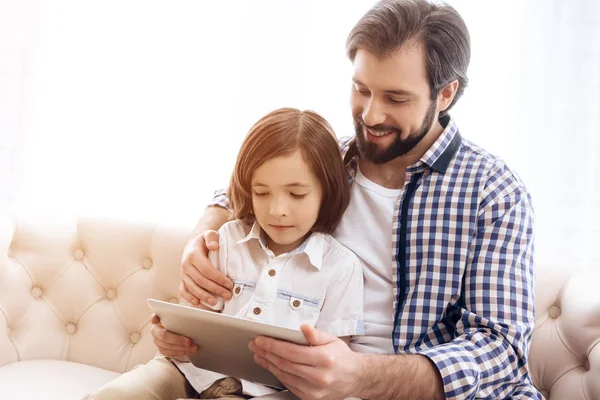 Glücklicher Vater und kleiner Sohn schauen auf Computer-Tablet. — Stockfoto