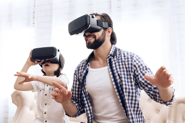 Father and son, using virtual reality glasses, play an interactive game.