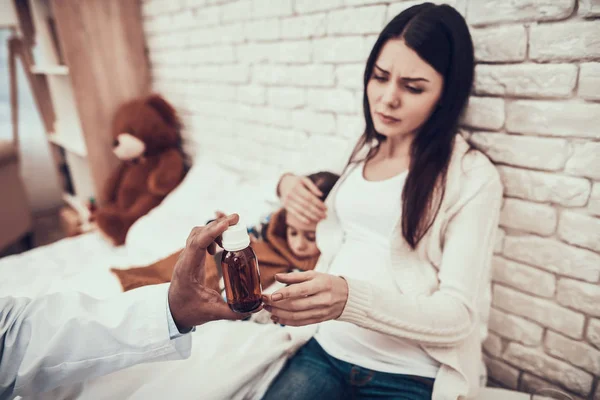 Médico indiano a ver pacientes em casa. Doutor está dando xarope para mãe grávida e filha . — Fotografia de Stock