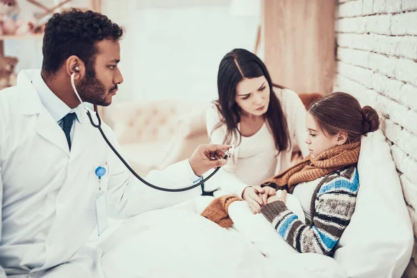 Médico indio atendiendo pacientes en casa. El doctor está usando estetoscopio. Madre e hija embarazadas . — Foto de Stock