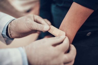 Hint doktor ofisinde hasta kabul. Doktor kızımın kolunda yama koyuyor.