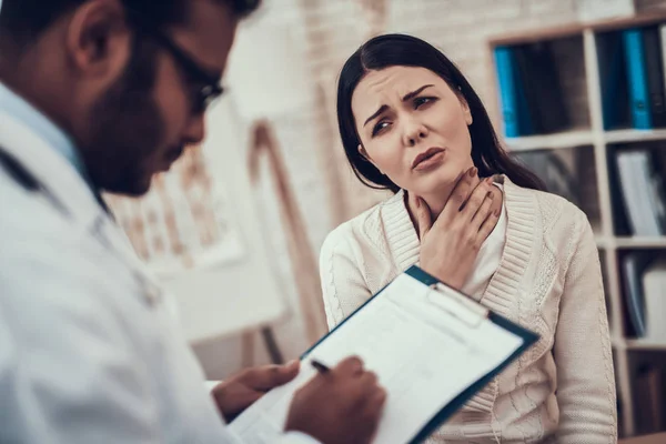 Medico indiano in visita da pazienti in ufficio. Il dottore sta ascoltando i sintomi delle donne. La donna ha mal di gola . — Foto Stock