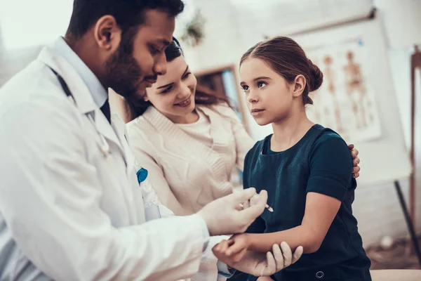 Médico indio viendo pacientes en el consultorio. El doctor está inyectando en el brazo de su hija. . — Foto de Stock