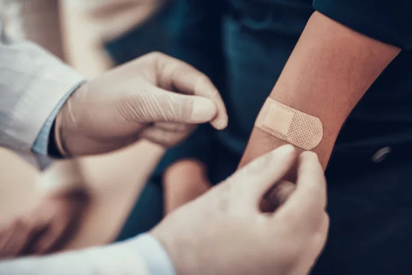 Indischer Arzt, der Patienten im Amt beobachtet. Arzt legt Pflaster auf den Arm der Tochter. — Stockfoto