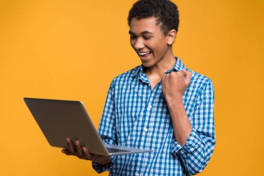 Mutlu Afro Amerikalı genç laptop ile çalışma.