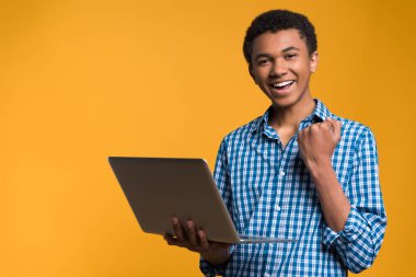 Mutlu Afro Amerikalı genç laptop ile çalışma.