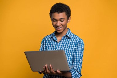Mutlu Afro Amerikalı genç laptop ile çalışma.