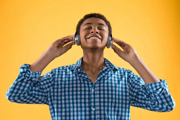 Afryki amerykański nastolatek w słuchawkach słucha muzyki. — Zdjęcie stockowe