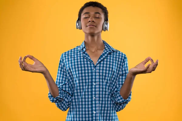 Afro-americano adolescente em fones de ouvido medita — Fotografia de Stock