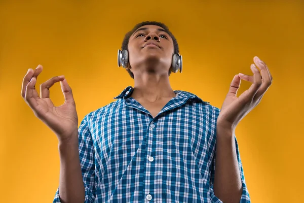 Afro-americano adolescente em fones de ouvido medita — Fotografia de Stock