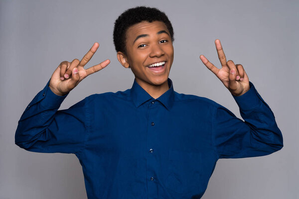 Cheerful African American teen shows gesture