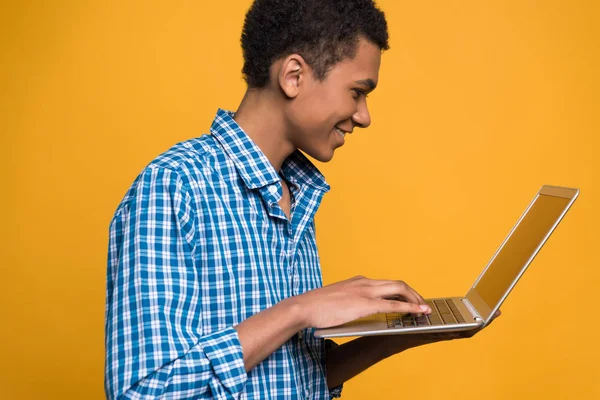 Fiatal afro-amerikai srác dolgozik a laptop. — Stock Fotó