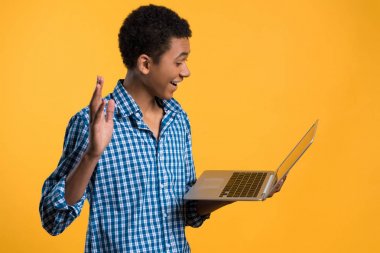 Genç Afrikalı-Amerikalı adam laptop ile çalışıyor.