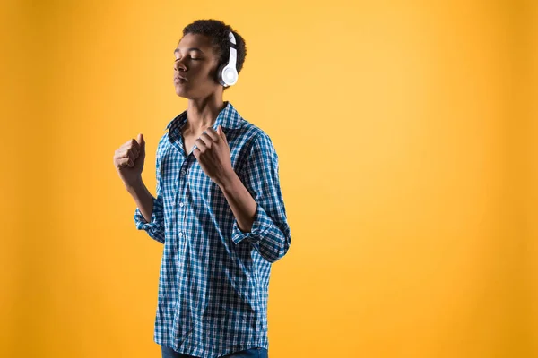 Afryki amerykański nastolatek w słuchawkach słucha muzyki. — Zdjęcie stockowe
