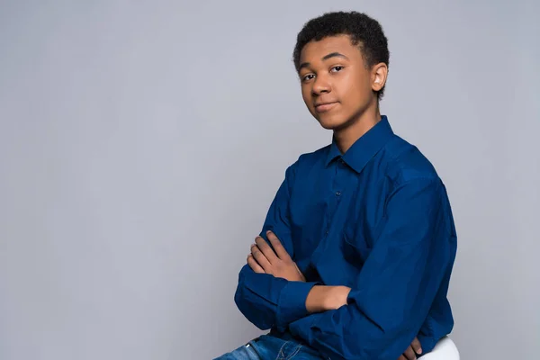 Zufriedener afrikanisch-amerikanischer Teenager im blauen Hemd. — Stockfoto