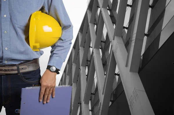 Ingeniero sosteniendo un casco amarillo —  Fotos de Stock