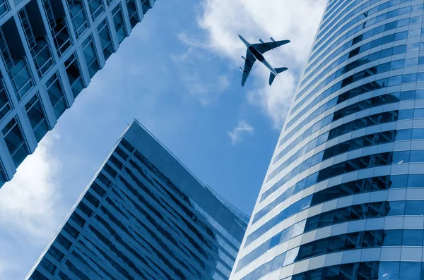 Airplane flying above  office buildings