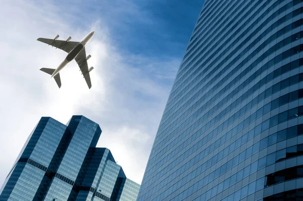 Airplane flying above  office buildings