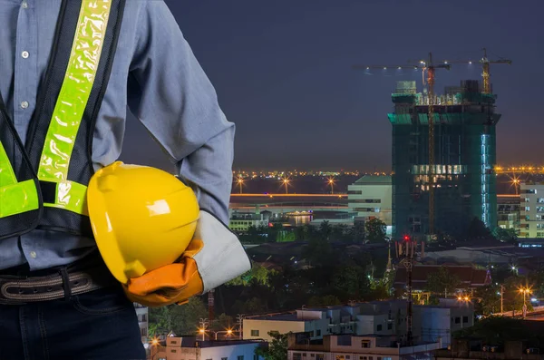 Engenheiro segurando um capacete amarelo — Fotografia de Stock