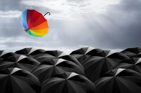 Guarda-chuva colorido em massa de guarda-chuva preto — Fotografia de Stock
